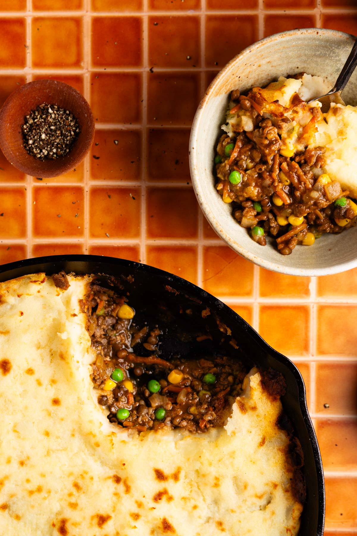 scooping out a serving of the cottage pie and putting it into a bowl
