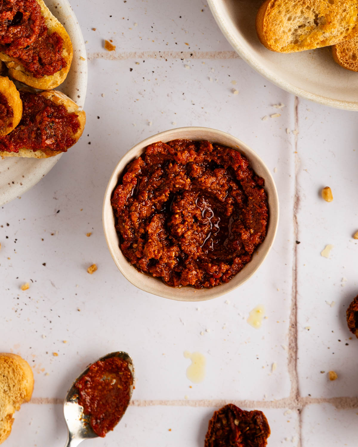 sun dried tomato pesto recipe in a white bowl, with bread