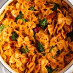 close up view of the pasta with sun dried tomato pesto in a white bowl