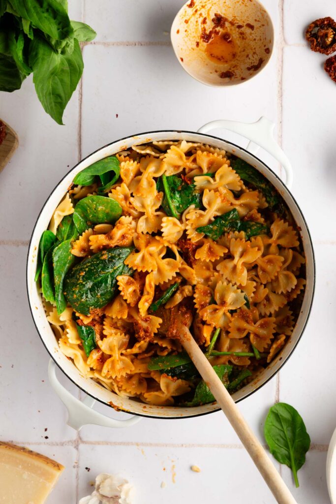 stirring all the ingredients into the cooked pasta with sun dried tomato pesto