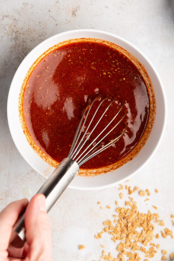 Whisking together the broth, tomato paste, and taco seasoning