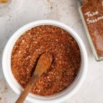 a while bowl of vegan taco seasoning with a little spoon inside