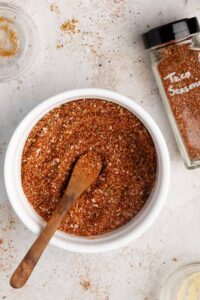 a while bowl of vegan taco seasoning with a little spoon inside