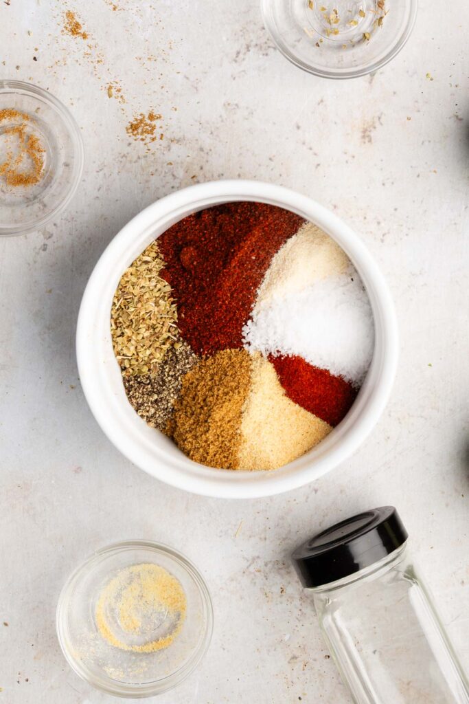 putting all the ingredients in one bowl to make vegan taco seasoning mix
