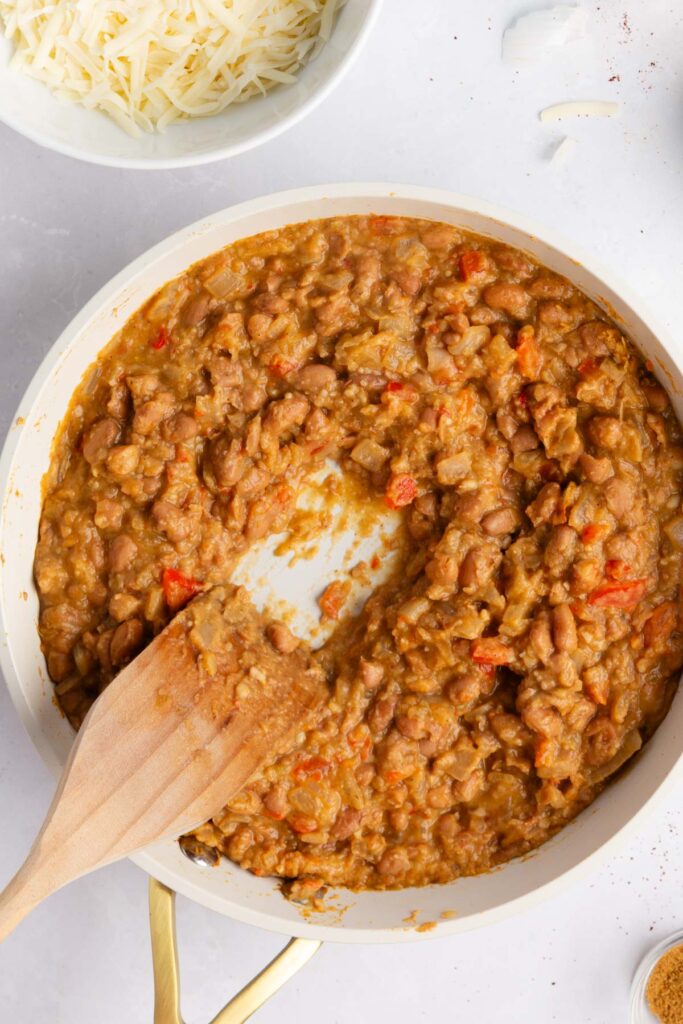 adding the beans to the burrito mixture