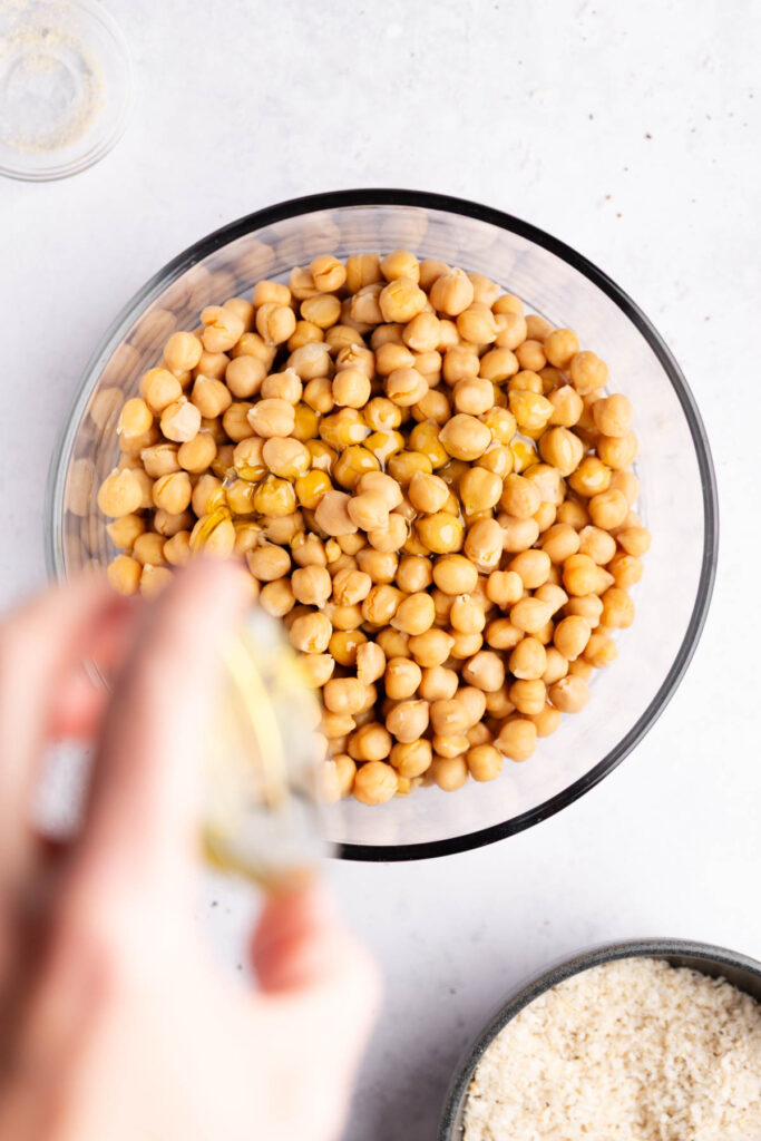 Seasoning being added to the chickpeas bowl.
