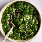 Garlic parsley sauce in a white bowl with a spoon.