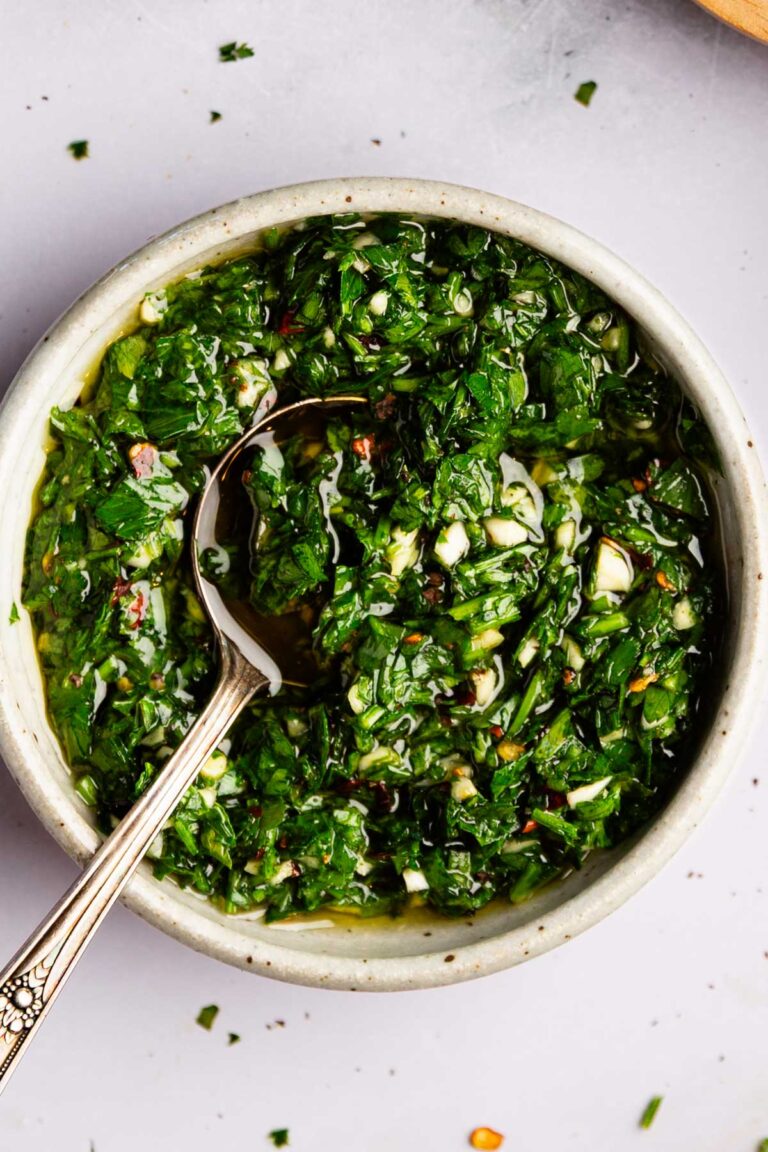 Garlic parsley sauce in a white bowl with a spoon.