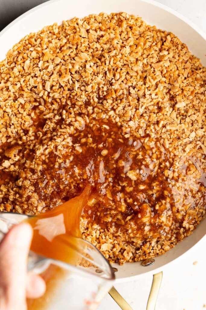 Seasoned broth poured over browned TVP in a skillet.