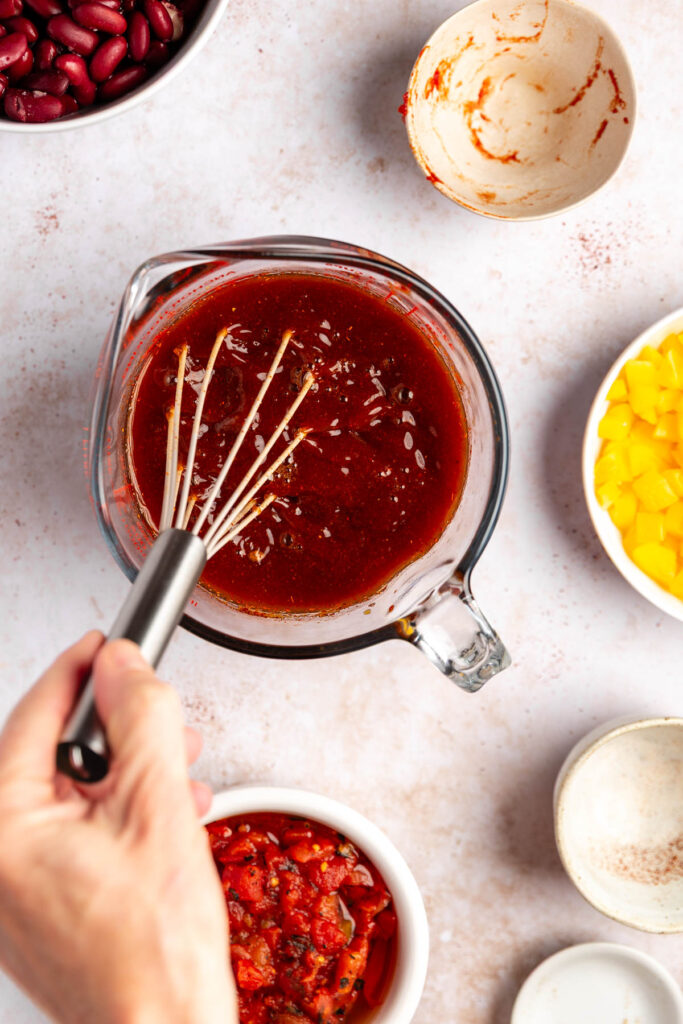 whisking broth, tomato paste and spices for tvp chili